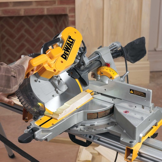 12 inch double bevel sliding compound miter sawing through a sheet of wood.